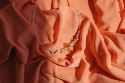 A beaded necklace sitting on a blanket.