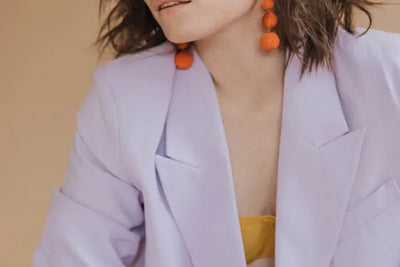 A woman poses for a photo wearing an American-made pink blazer.