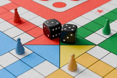Close-up of a Ludo board with vibrant red, green, blue, and yellow sections. Dice and matching game pieces are placed on the board, evoking a fun and colorful family game night atmosphere.