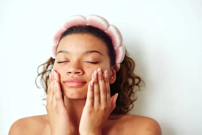 American made face cleansers being used by a woman in a bathroom for her night time skin care routine.