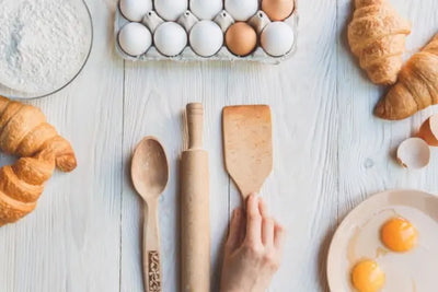 A wooden spin, spatula and other cooking utensils. 