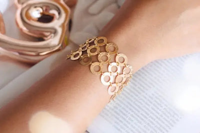 A woman wearing a golden cuff bracelet.