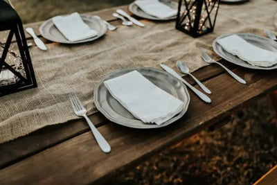 Plates, silverware and trays sitting on a table.
