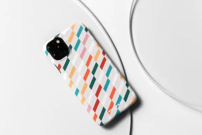 A colorful phone case with diagonal striped patterns placed on a white surface. 