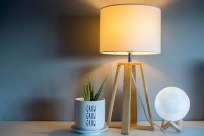 A modern wooden lamp on a dresser.