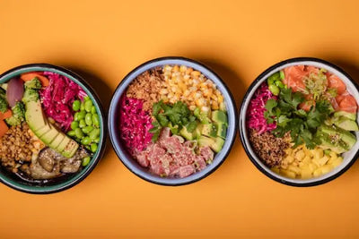 Three prepared meals sitting on a table.