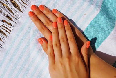 A women's hands on a beach towel.