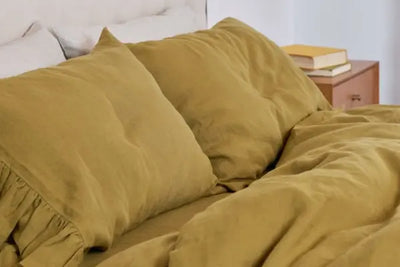 Two brown pillow shams that were American made lay neatly on a bed.