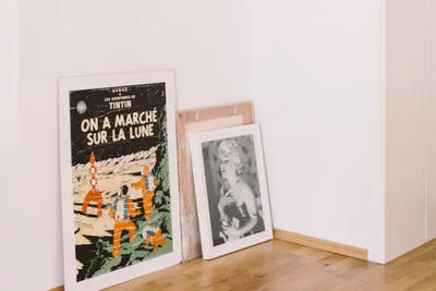 Three wall prints that were designed and made in America sit on a floor.