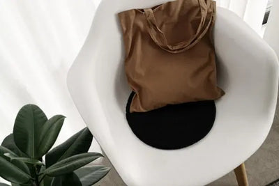A brown tote sitting on a white chair
