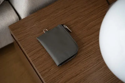 A brown leather wallet that was made in the USA sits on an end table