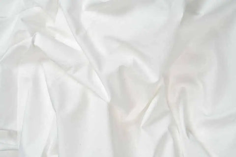 Soft folds and gentle creases highlight the smooth, slightly shiny texture of American Blossom Linens Natural Cotton Bed Pillowcases, made from luxurious USA-grown cotton for a flowing, elegant look.