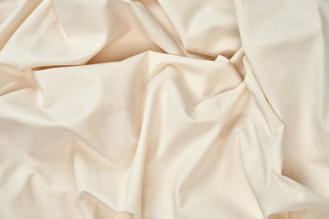 Natural Cotton Bed Pillowcases by American Blossom Linens feature an off-white hue with subtle dark specks and gentle creases, crafted from luxurious USA-grown cotton fibers.