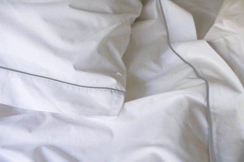 Close-up of American Blossom Linens Cotton Piping Design Bed Sheet Set, featuring USA-grown cotton with a subtle grey trim, neatly arranged for a soft and clean look.