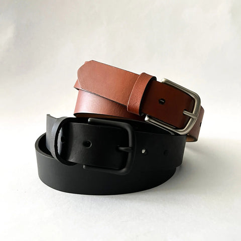 Two Rogue Industries Chamberlain Leather Belts, 1.25 wide—one brown with a silver buckle and one black with a matte black buckle—are coiled and stacked on a plain white background.