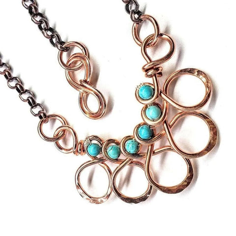 The As Seen on Ashley Liao Copper Turquoise Wire Wrapped Necklace by Alexa Martha Designs features four turquoise jasper stones, copper wire loops, and a mixed metal chain with an S-shaped clasp.
