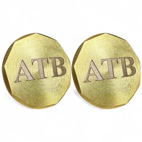 Fairway Reserve Personalized Ball Markers (Set of 2): Two shiny, gold, octagonal coins engraved with ATB at the center—perfect for marking your spot on the green. Shown on a white background.