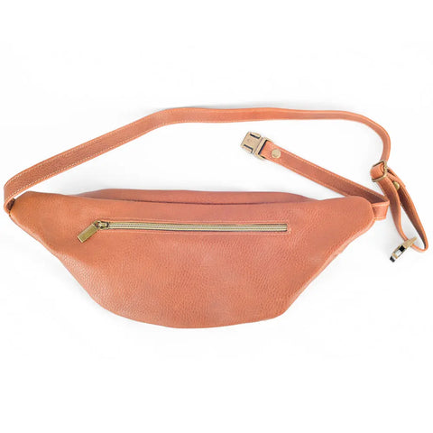 The Crescent Leather Sling Bag by Rogue Industries is a tan full-grain leather crossbody with an adjustable strap, gold zipper, and buckle, shown on a white background.