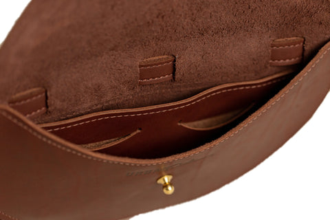 Close-up of the Urban Southern Half-Moon Belt Bag’s interior: full-grain leather with suede lining, open pocket, and brass clasp on the front flap. Detailed stitching highlights this USA-handcrafted accessory’s quality.