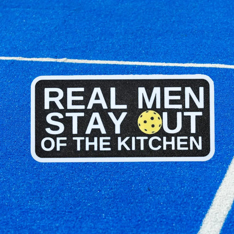 The Chatelet Manufacturing Pickleball Real Men Stay Out of the Kitchen Fridge Magnet features a yellow pickleball as the “O” in OUT—a funny, made-in-USA gift for pickleball players and fans.