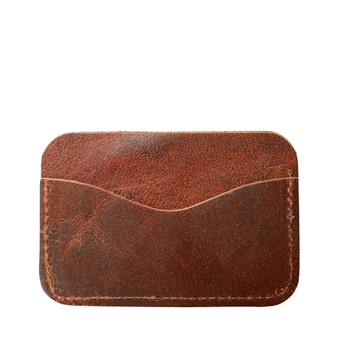 The Rogue Industries Moose Leather Card Case is a brown Canadian moose leather holder featuring visible stitching and a curved top opening, displayed against a white background.