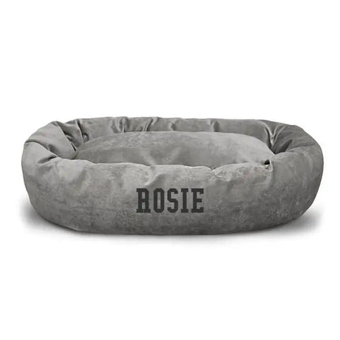 A soft, round, gray Villa Bagel Dog Bed - Personalized by Majestic Pet with ROSIE in bold black letters on the front. Raised, cushioned sides and a plush center provide ultimate comfort.