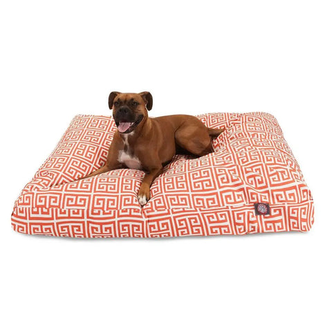 A brown dog with a white chest lies on the Majestic Pet Towers Rectangle Dog Bed, featuring a large orange and white geometric pattern and a removable cover. The relaxed dog looks ahead with its mouth slightly open.