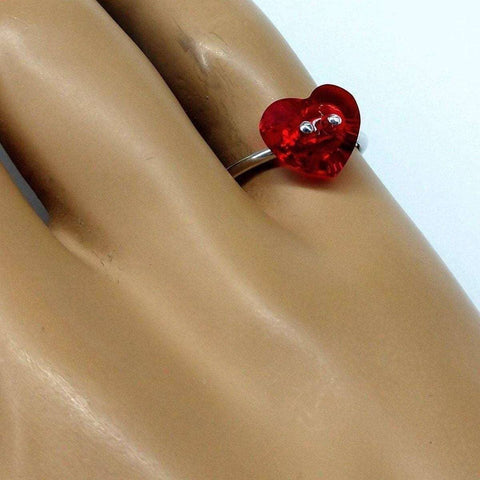 A close-up of a hand wearing Alexa Martha Designs’ I Love You Crystal Heart Bling Ring—a sterling silver ring with a red, heart-shaped charm and googly eyes, perfect for a playful Valentine’s Day gift.