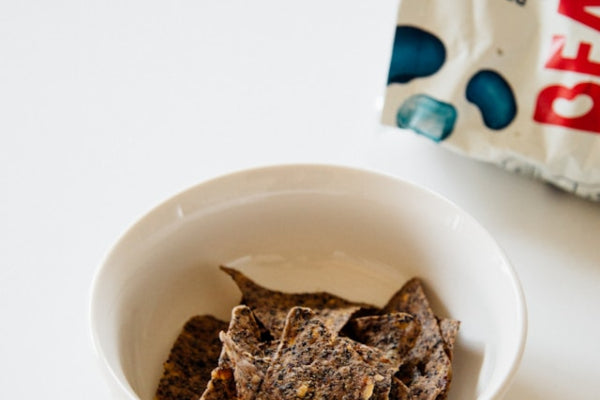 Bowl of crackers with a colorful bag in the background