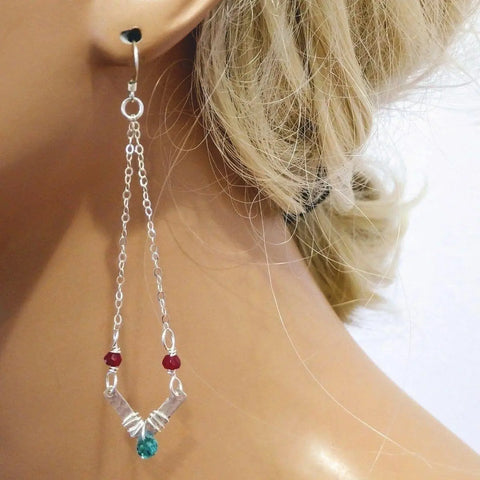 Close-up of a womans ear wearing Alexa Martha Designs Sterling Silver Chevron Hot Pink Green Gemstone Earrings. Her blonde hair is pulled back, set against a light, plain background.