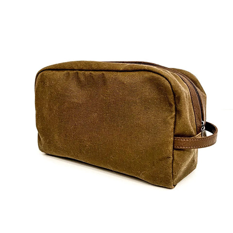 The Rogue Industries Waxed Canvas Dopp Kit features brown waxed canvas, a zipper closure, and a small side handle, photographed on a white background.
