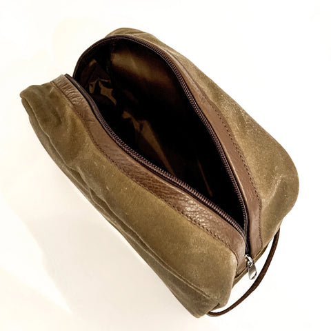 The Rogue Industries Waxed Canvas Dopp Kit, in brown with leather accents and a zipper, is displayed open on a white background, showing its dark empty interior.
