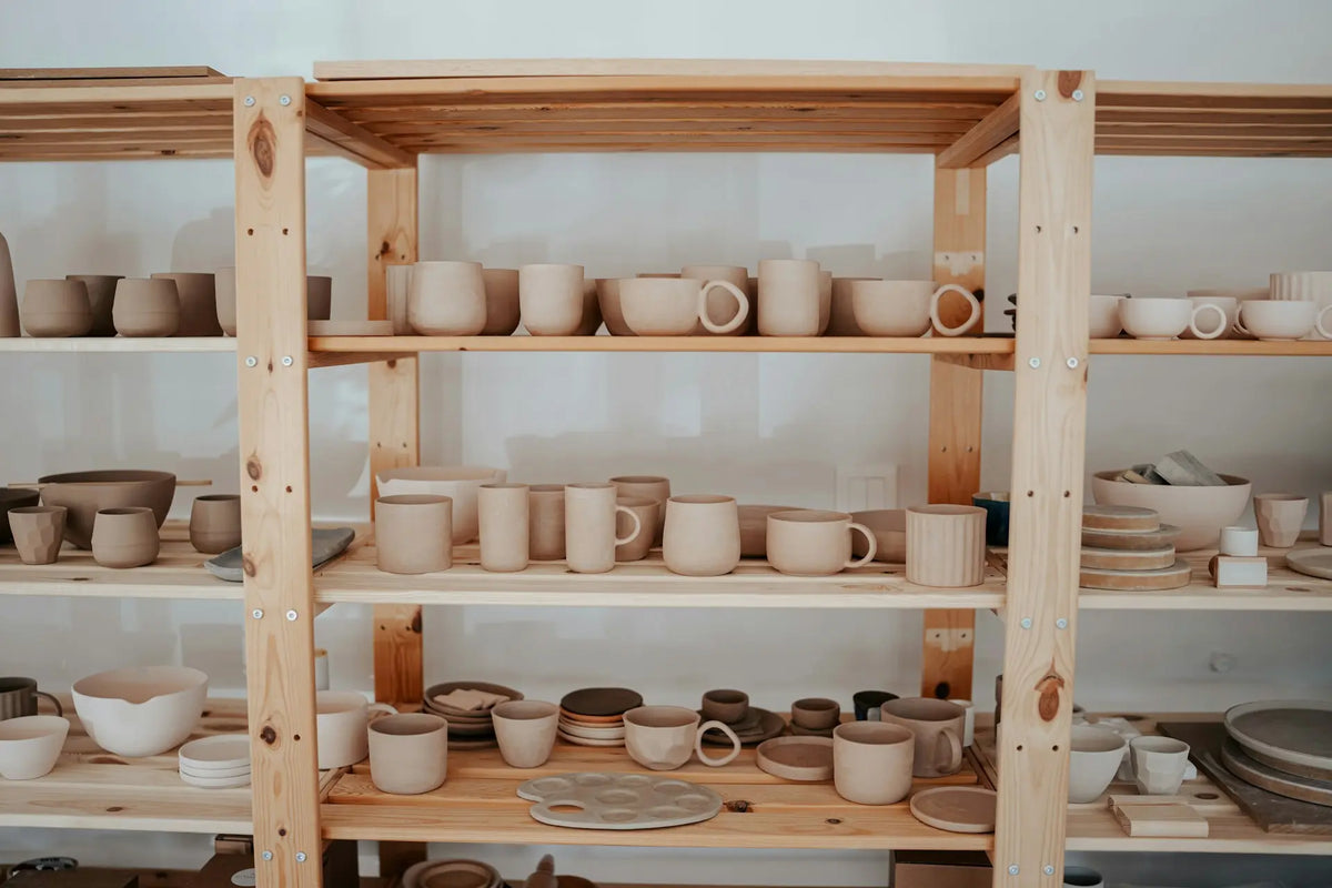 Wooden shelves with various ceramic items in a studio setting