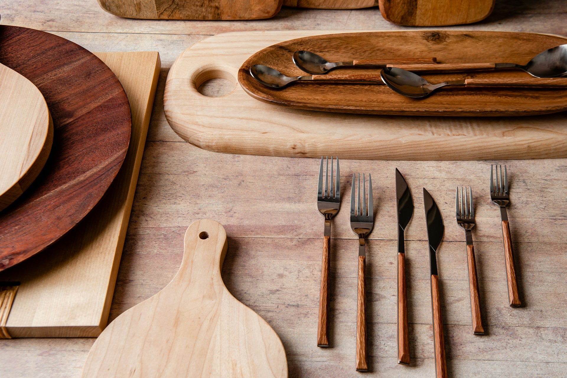 Wooden cutting boards and kitchen utensils on a wooden surface